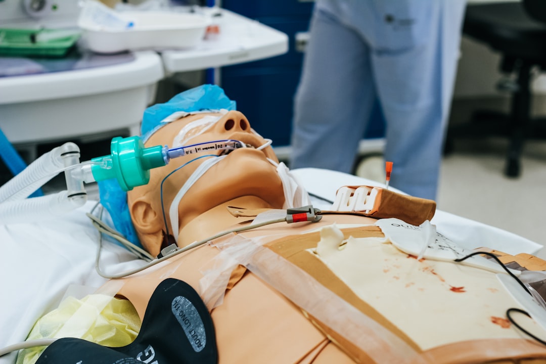 Nurse practicing defibrillator pad placement on a training manikin during an ACLS megacode
