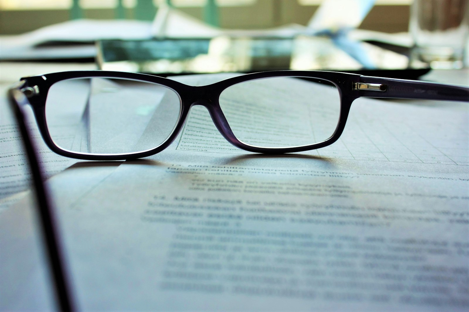 Reading glasses resting on a printed document, the fine print where a completion-filtered pass rate and its missing sample size are disclosed