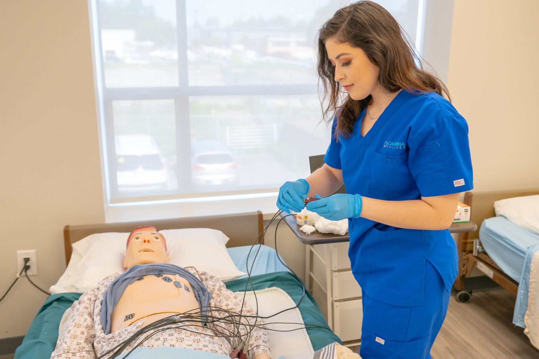 Nursing student practicing clinical skills on a training manikin before the ATI Comprehensive Predictor