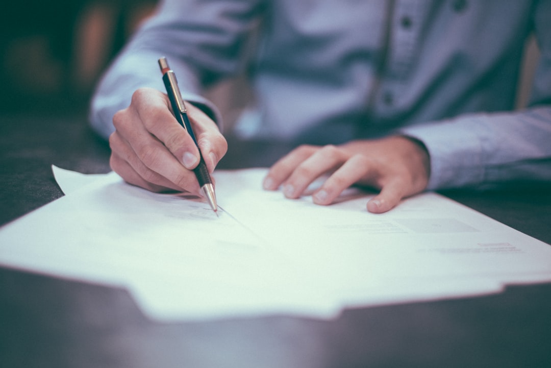 Filling in an application form by hand, the eligibility paperwork AACN requires before a CCRN candidate can book the exam