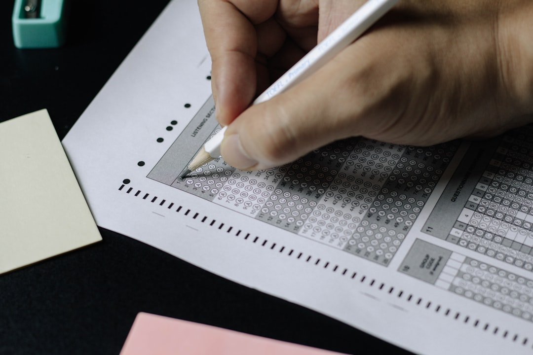 Pencil filling in a bubble answer sheet, illustrating the CCRN raw cut score of 83 correct out of 125 scored items