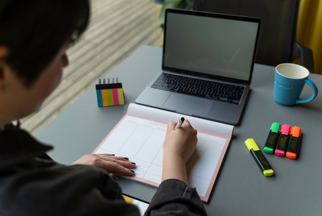 Nurse planning a study schedule in a weekly planner beside a laptop, preparing for the CCRN exam
