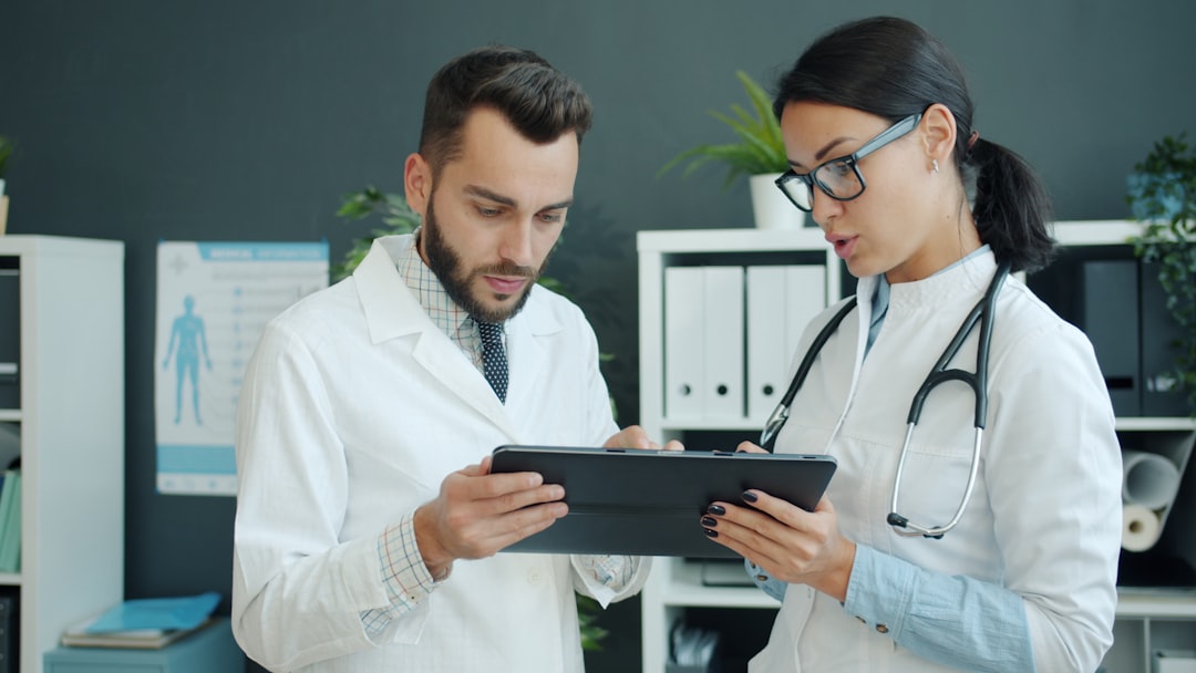 Two clinicians reviewing unit quality data on a tablet as part of a system-level practice review