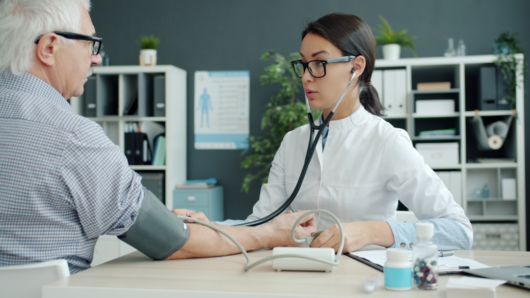 Nurse practitioner taking an older patient's blood pressure during a routine geriatric check