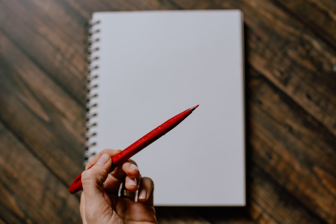 Proofreading a sentence with a red pen to correct grammar and punctuation