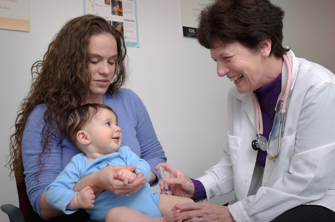 Clinician assessing a young child during a pediatric examination with a caregiver present