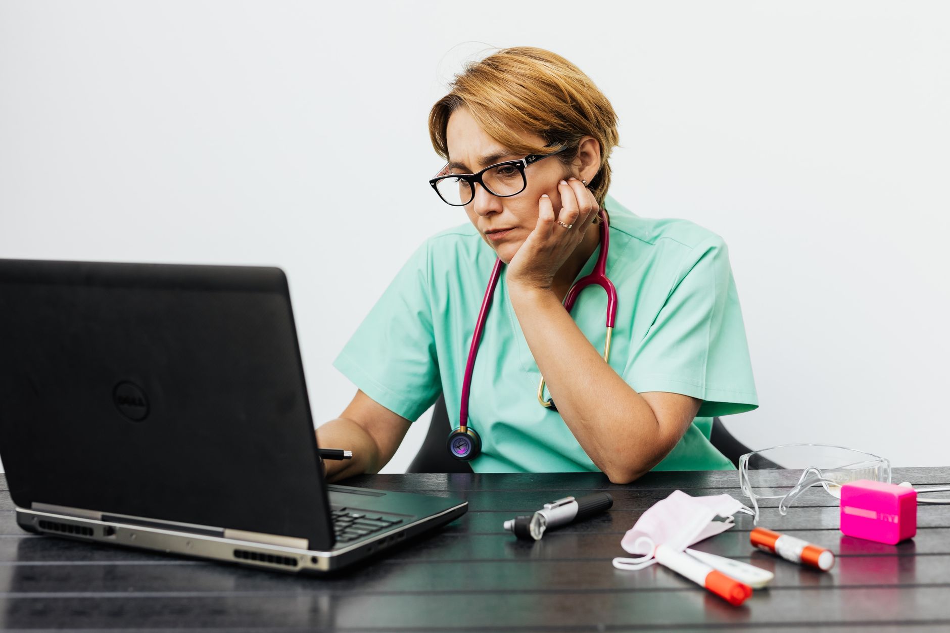 Nurse working through patient documentation on a laptop, the OASIS assessment burden that follows every home health visit