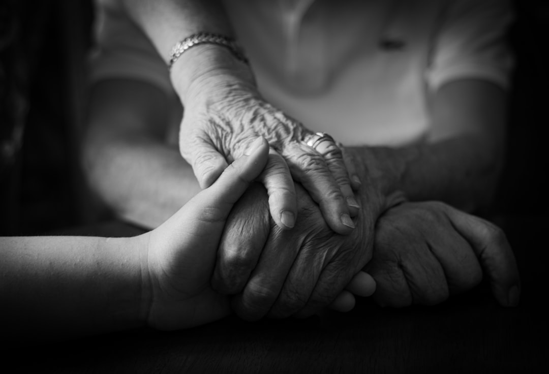 Two hands held together, representing the family support central to hospice nursing