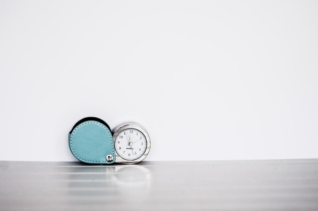 Desk clock beside study materials, representing the per-section time limits on the HESI A2