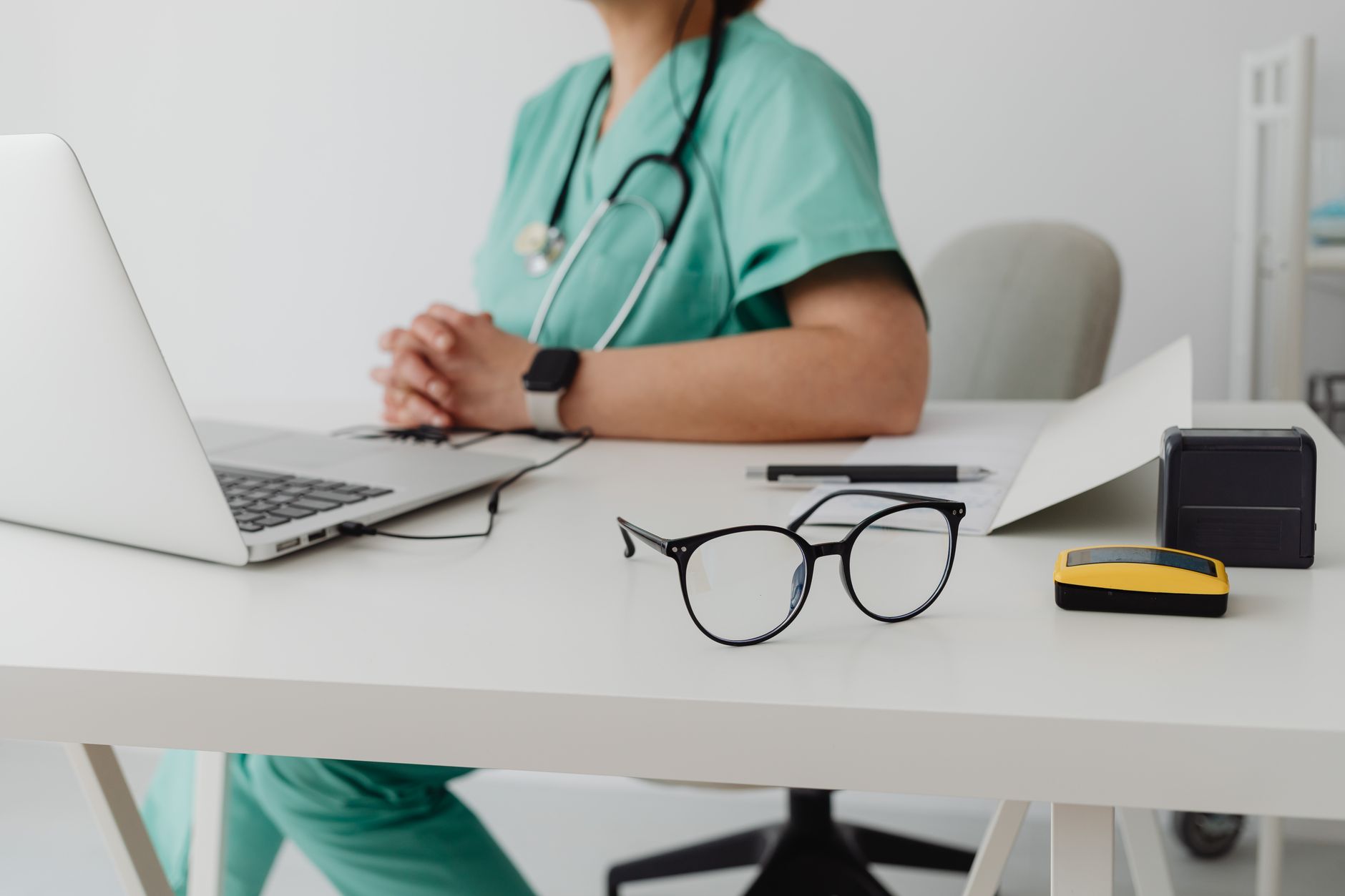 Nurse in scrubs working at a laptop, preparing for the CRNI infusion nursing certification exam