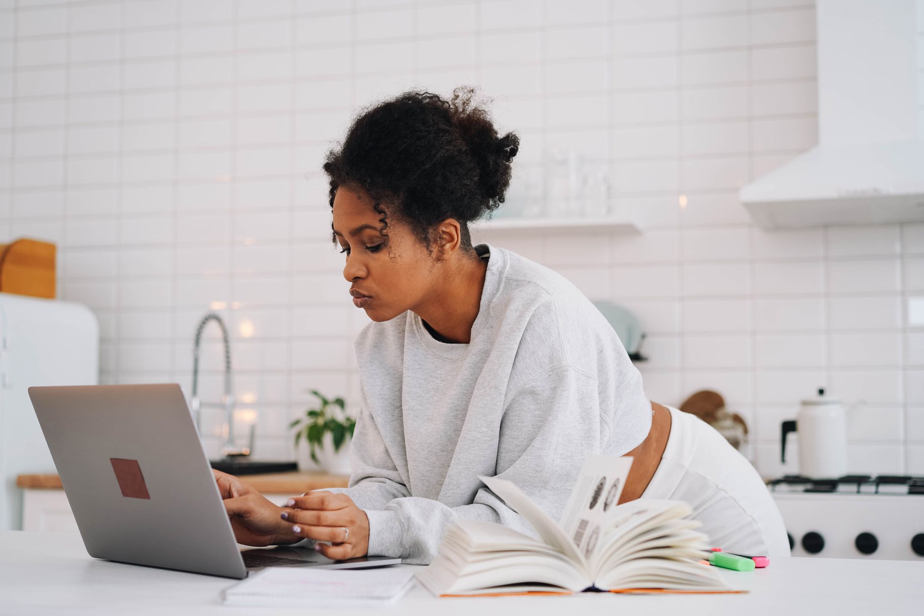 LPN studying at home on a laptop, the online and part-time coursework most LPN to BSN bridge programs are built around