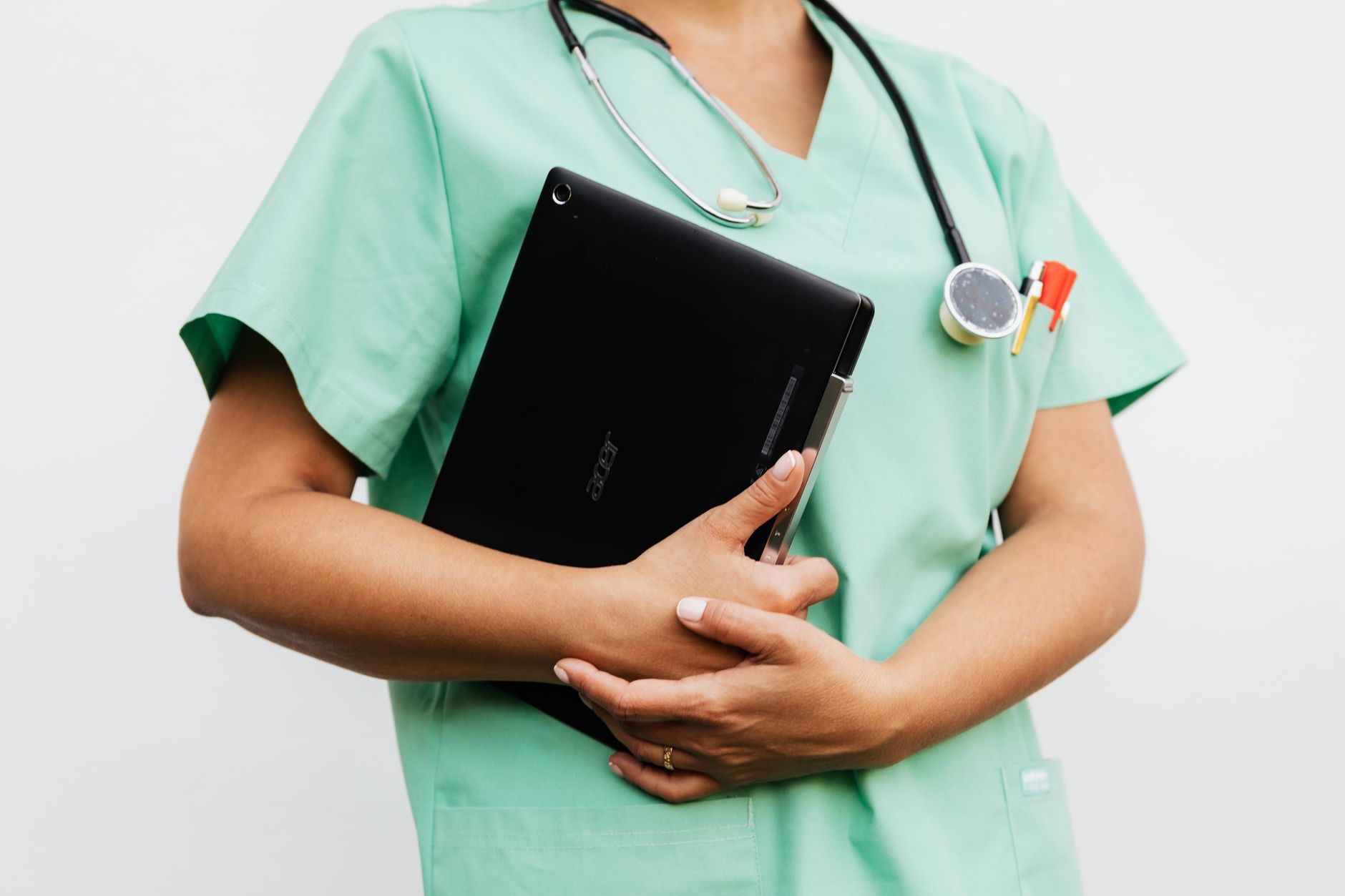 Nurse holding a tablet and stethoscope, preparing for the NCLEX-RN after completing an LPN to RN bridge program