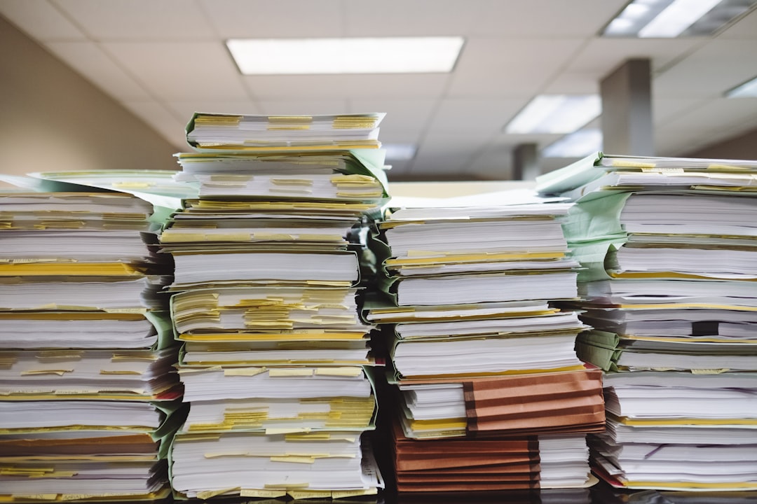 Stacks of tabbed paper files representing licensure application documentation
