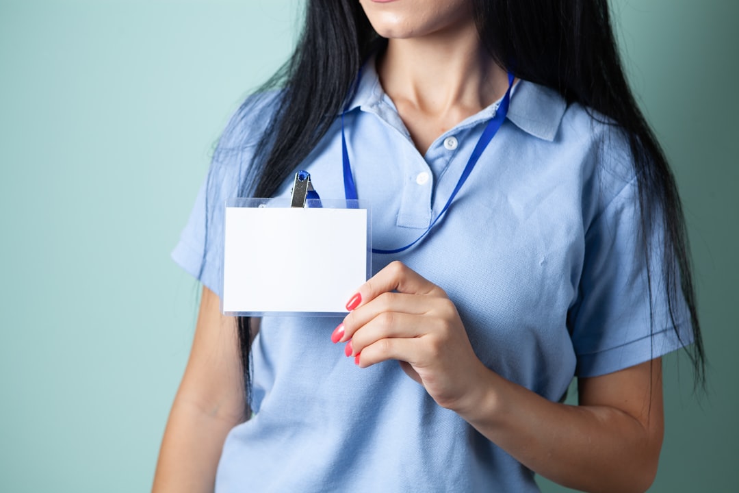 Healthcare worker holding a blank identification badge representing licensure