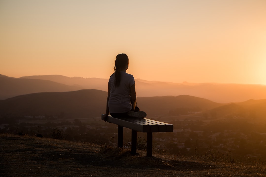 Person sitting quietly at sunset, representing stamina and anxiety management