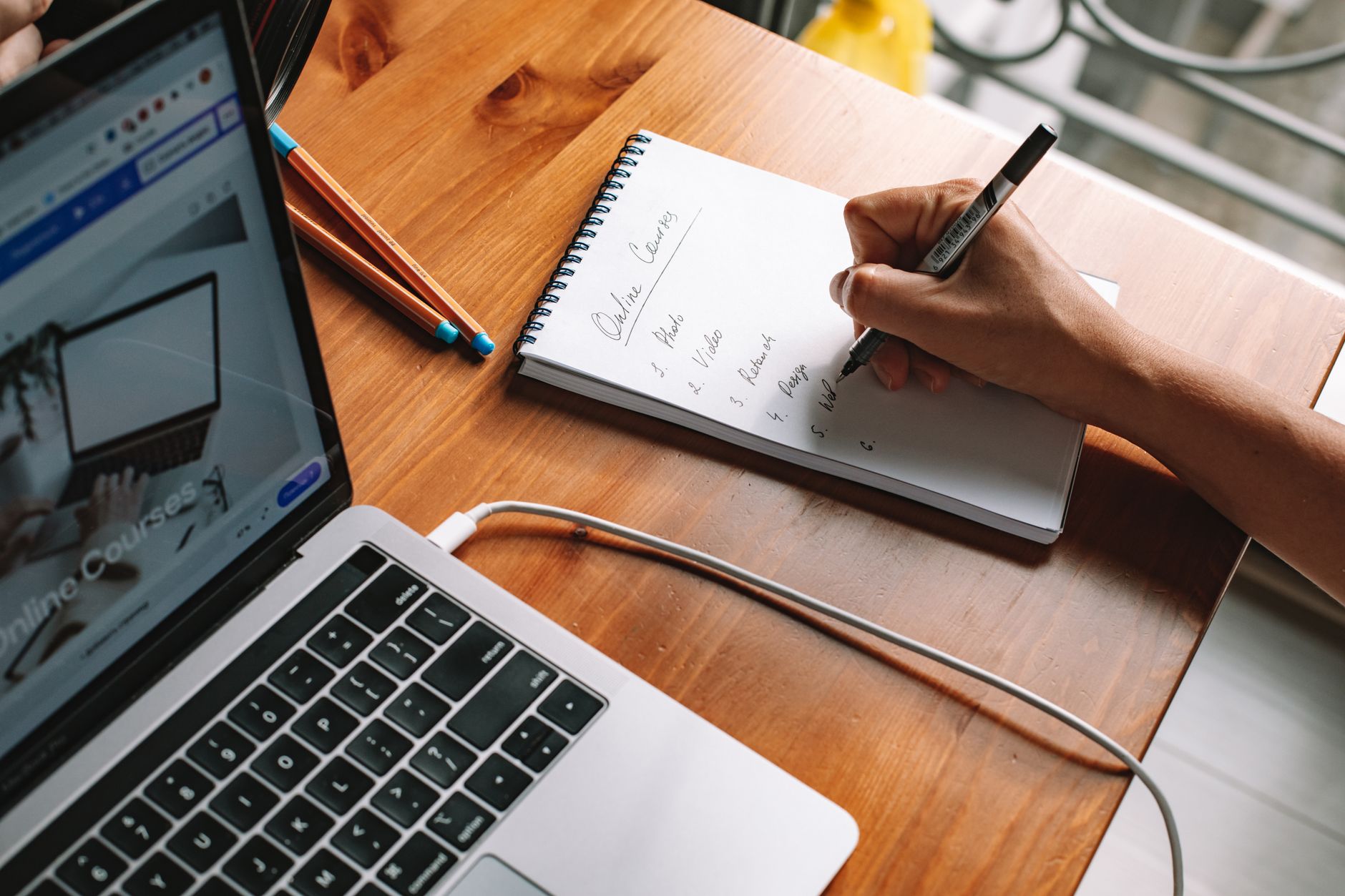 Nurse completing online continuing education coursework with written notes