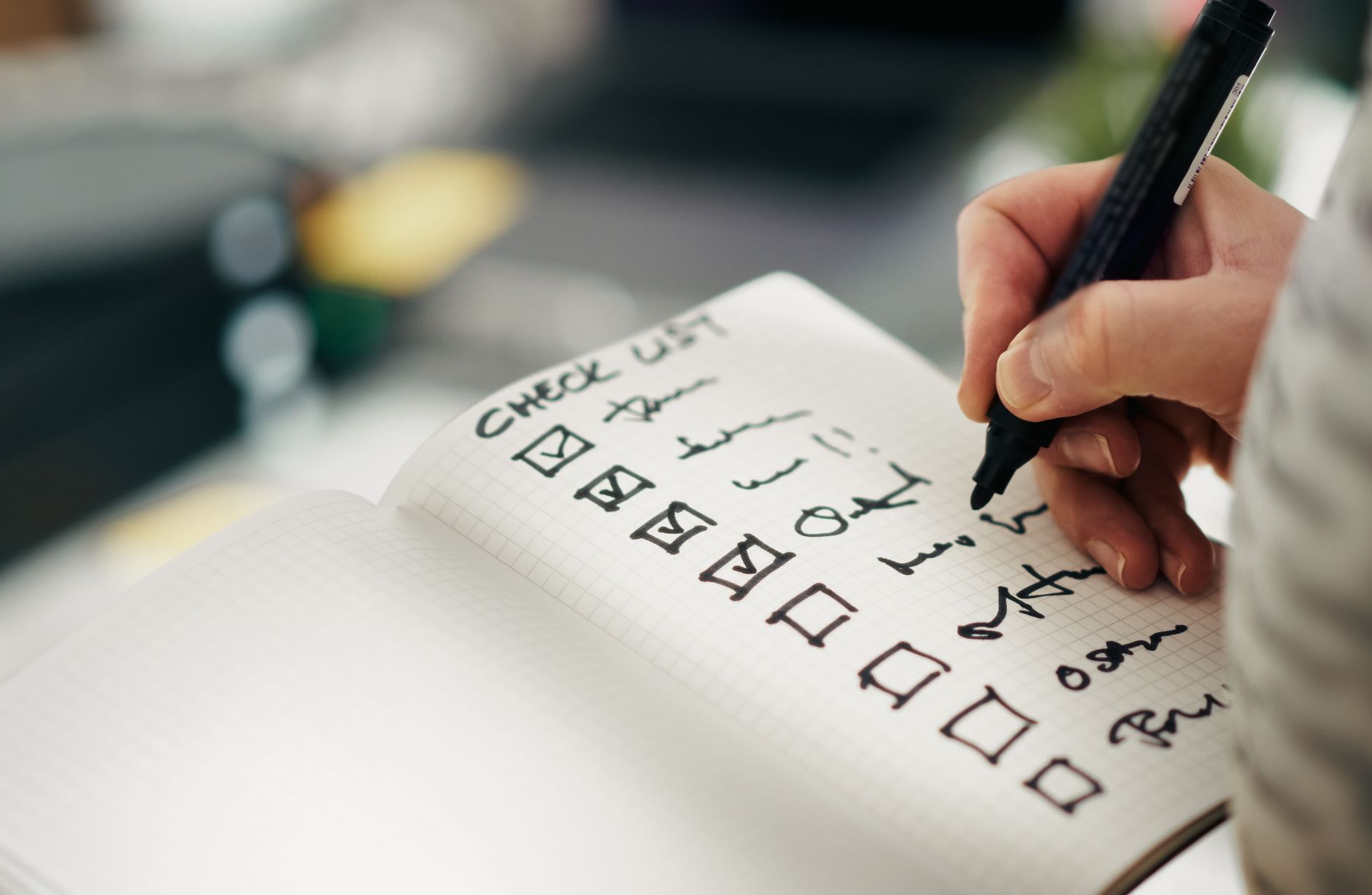 Hand working through a written checklist, one item at a time