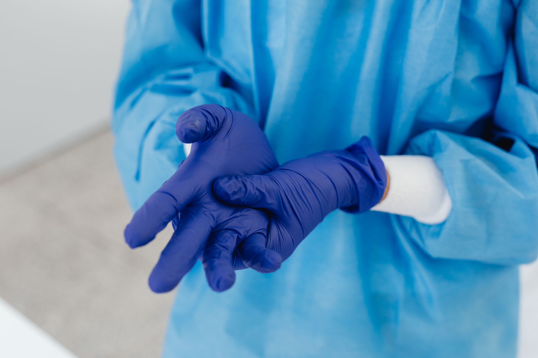 Nurse wearing protective gloves before handling hazardous chemotherapy drugs