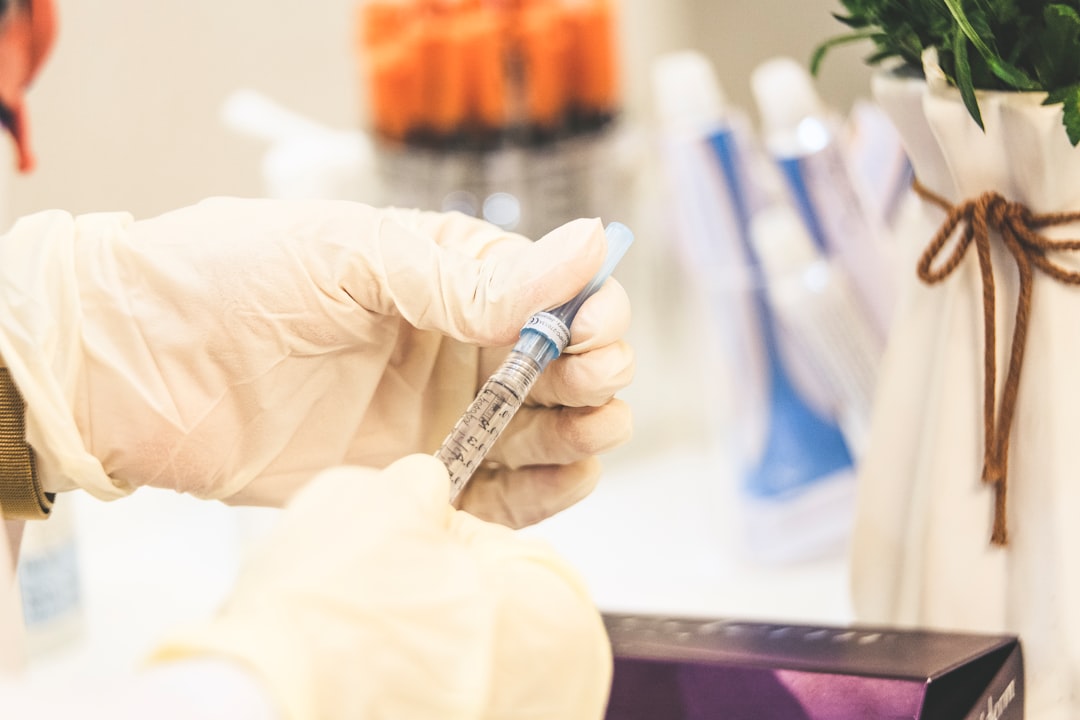 Gloved clinician preparing a labeled syringe for medication administration