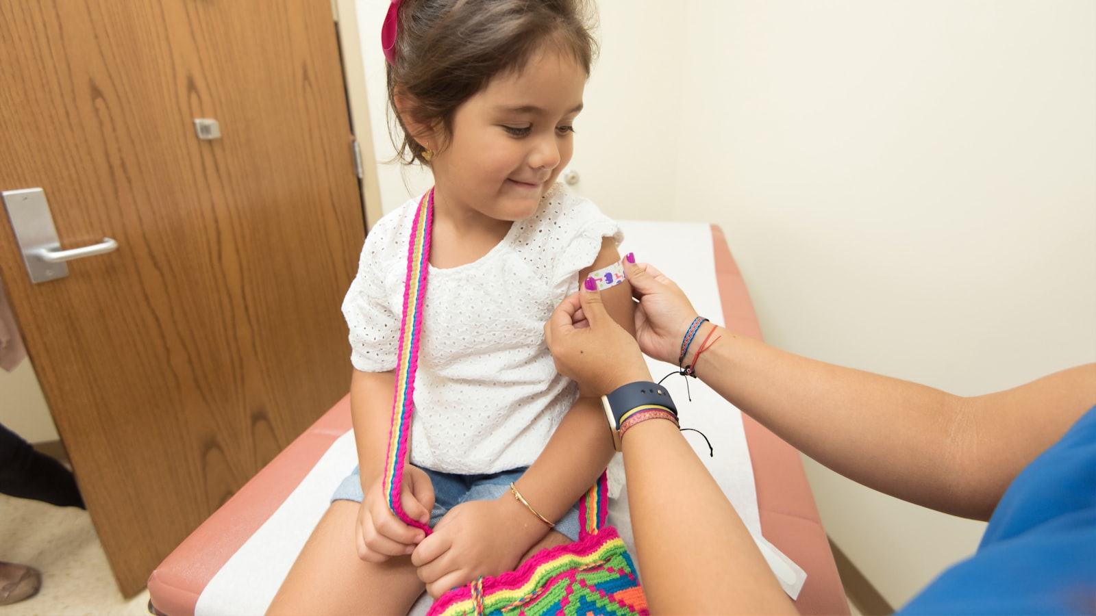 Nurse caring for a school-age child, illustrating the age span a PICU nurse covers from infants through adolescents
