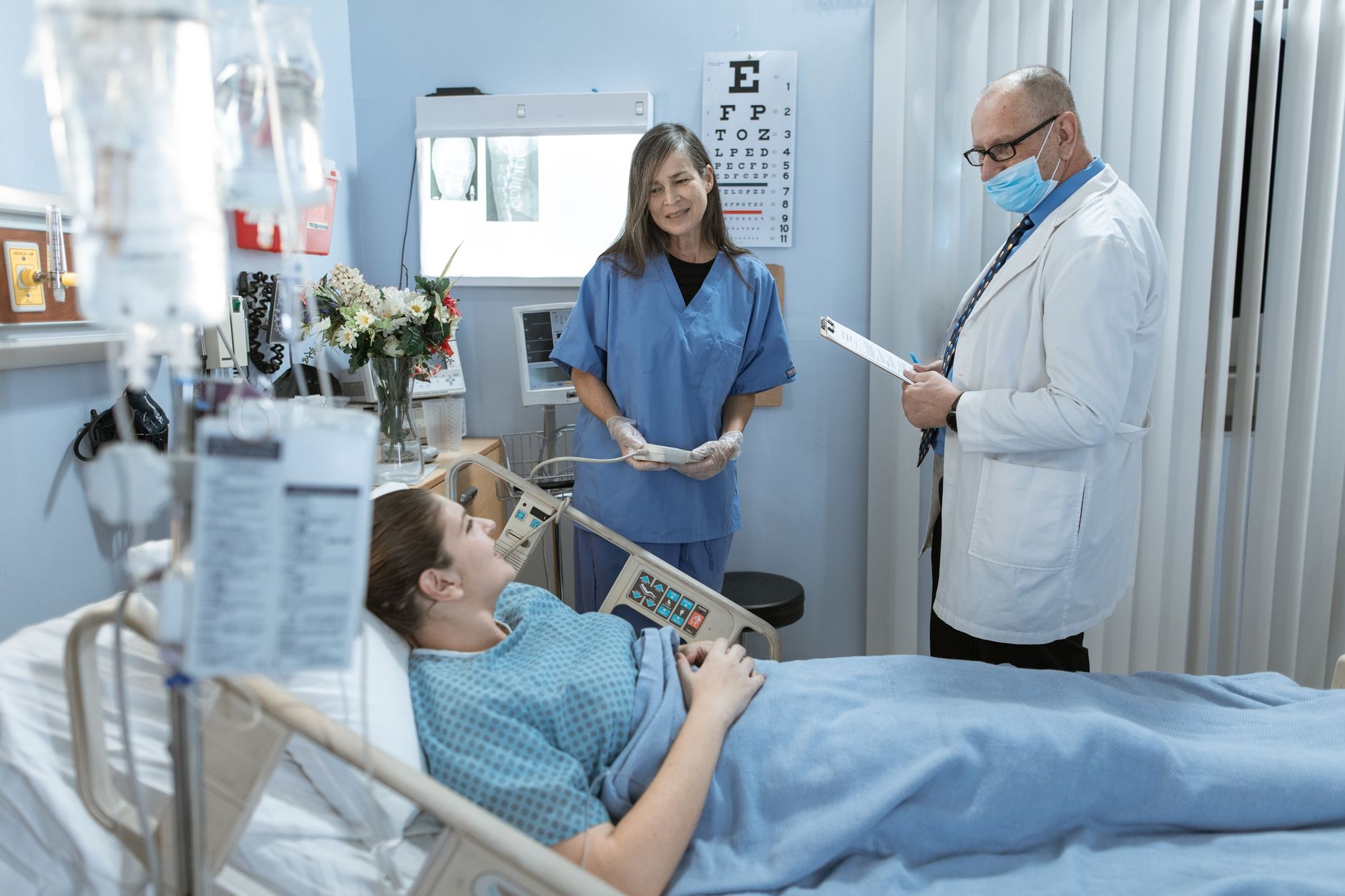 Nurse and physician reviewing a patient chart together at the bedside