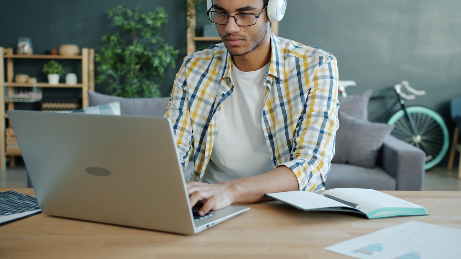 Student working at a home desk with headphones and a laptop, the workspace an online TEAS check-in scan has to pass