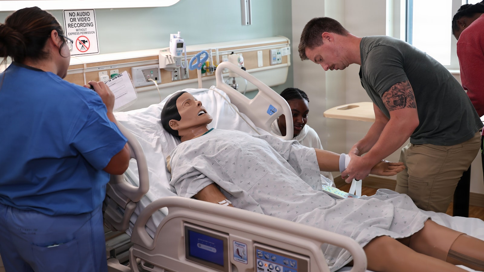 Nurses practising assessment skills on a simulation manikin, the core duties that hold in every nursing setting